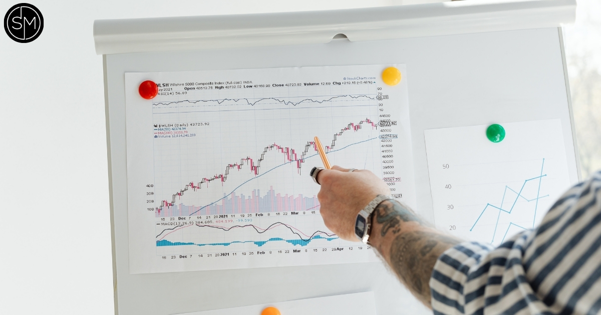 Printed trading chart being pointed at on a board