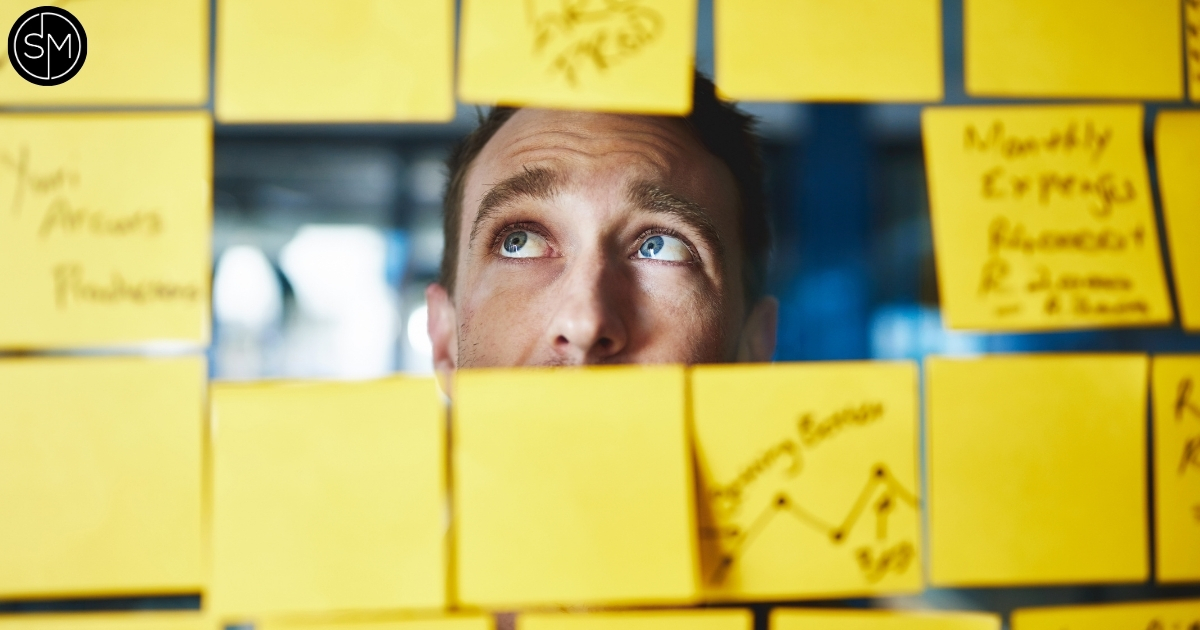Business owner surrounded by sticky notes and business planning ideas